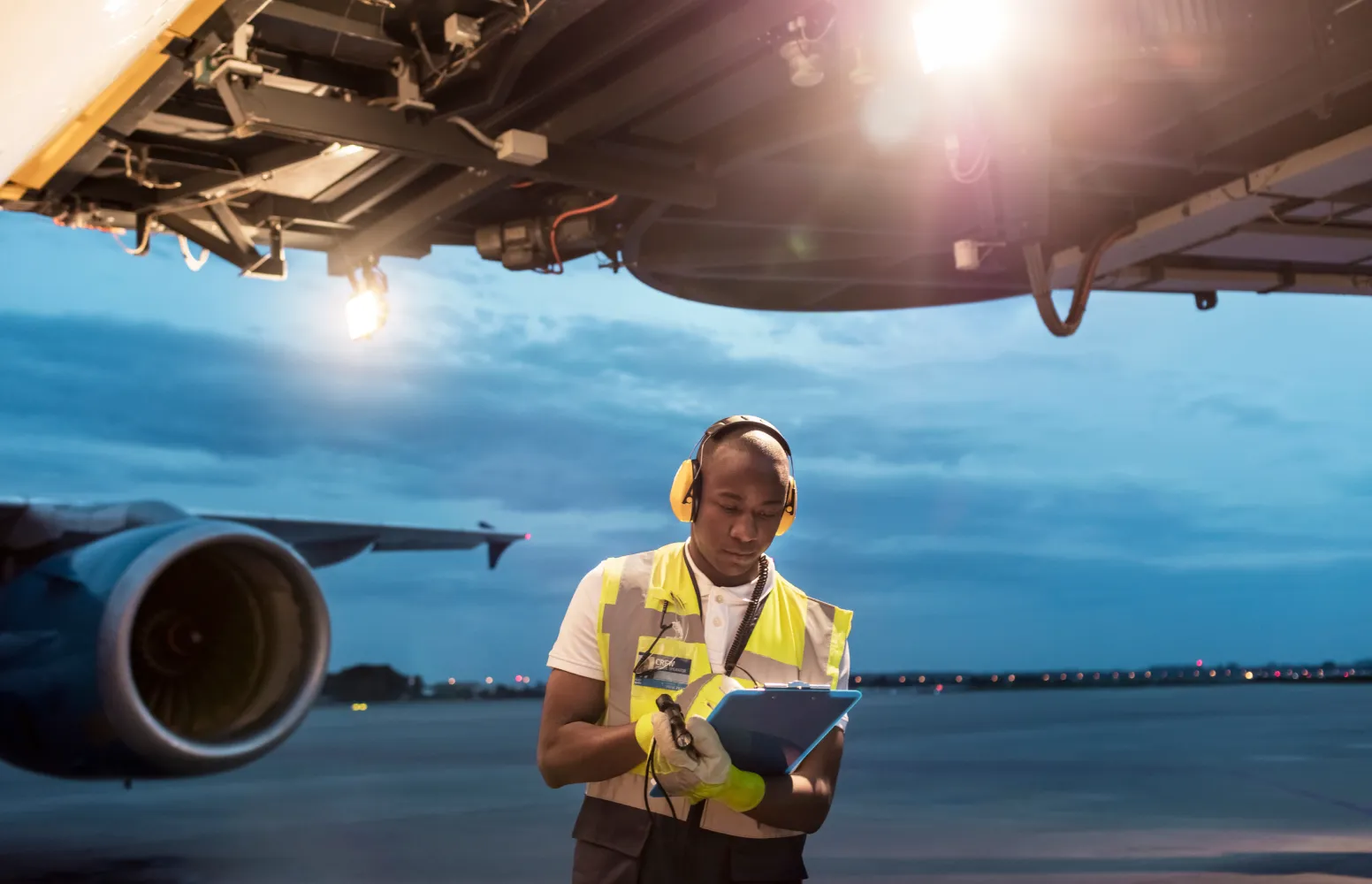 67038a50c41d8b7f3d801654_Airport worker in front of aircraft